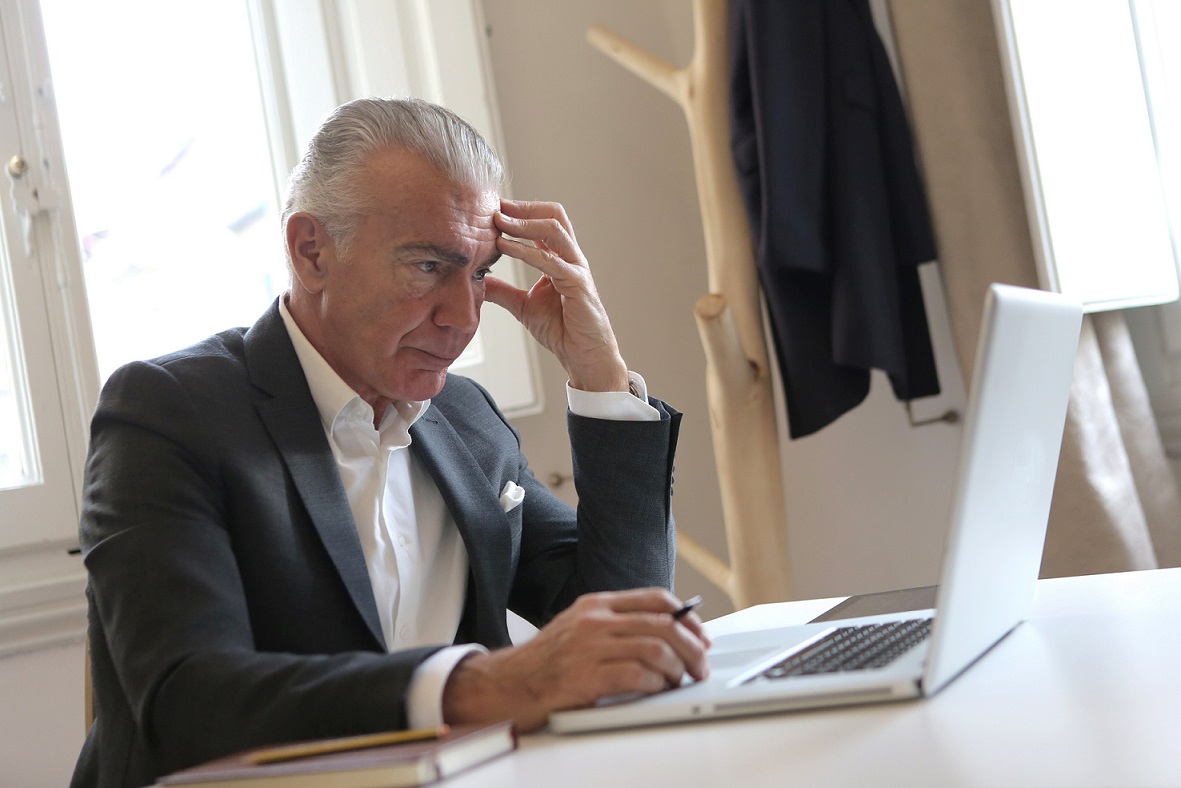 man-in-black-suit-jacket-while-using-laptop-3789100